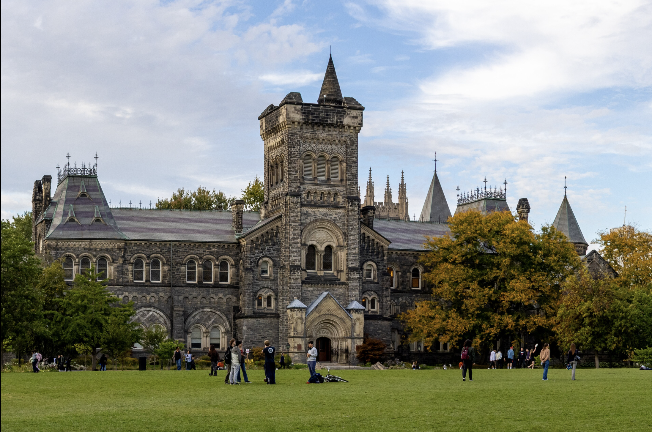 University of Toronto campus building surrounded by trees and lawn